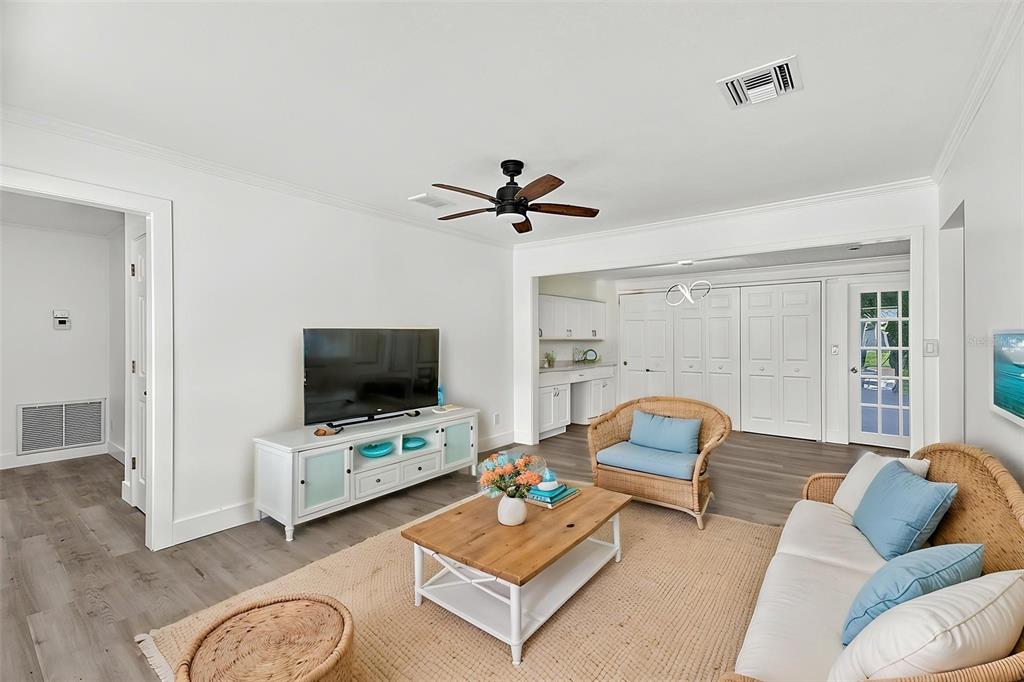 A living room features white walls, wood-look flooring, a ceiling fan, and wicker furniture — 315 DURRANCE STREET, PUNTA GORDA, FL