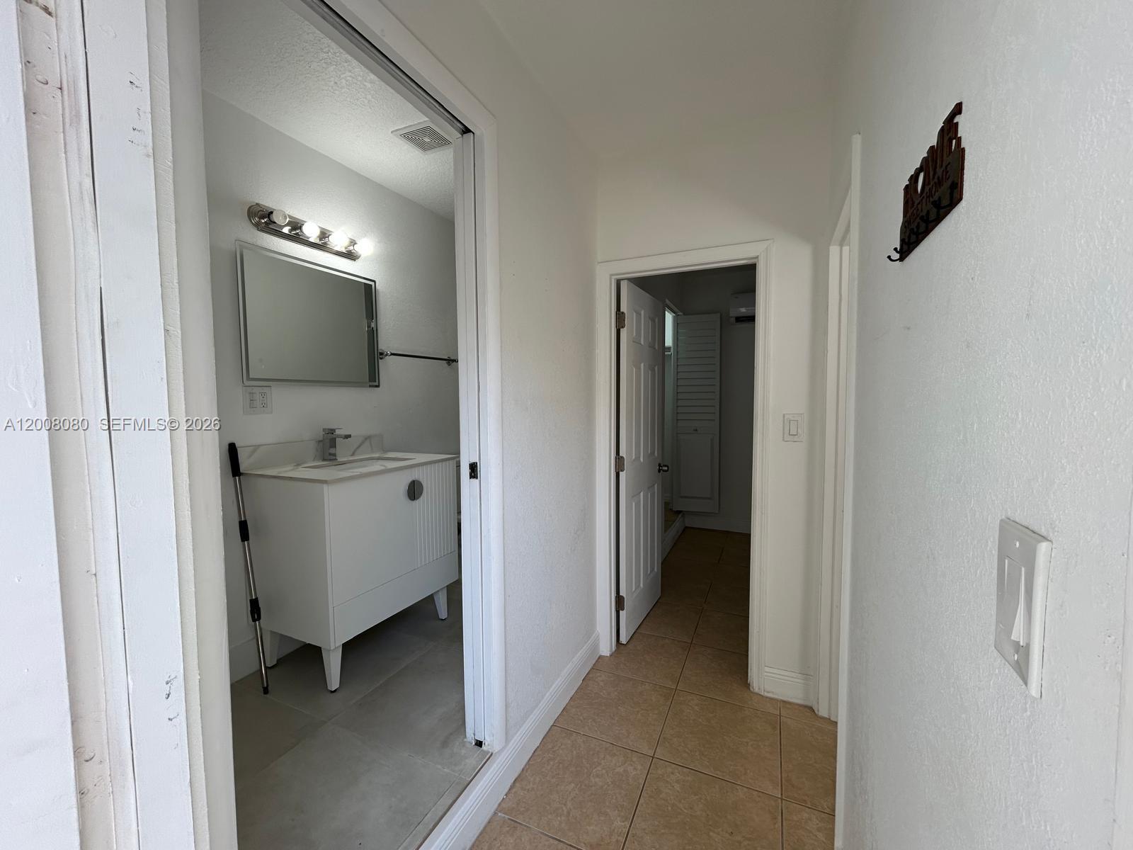 A hallway leads to a bathroom with a white vanity and a separate interior door — 14731 SW 170th Ter # 1, Miami FL 33187, MIAMI, FL