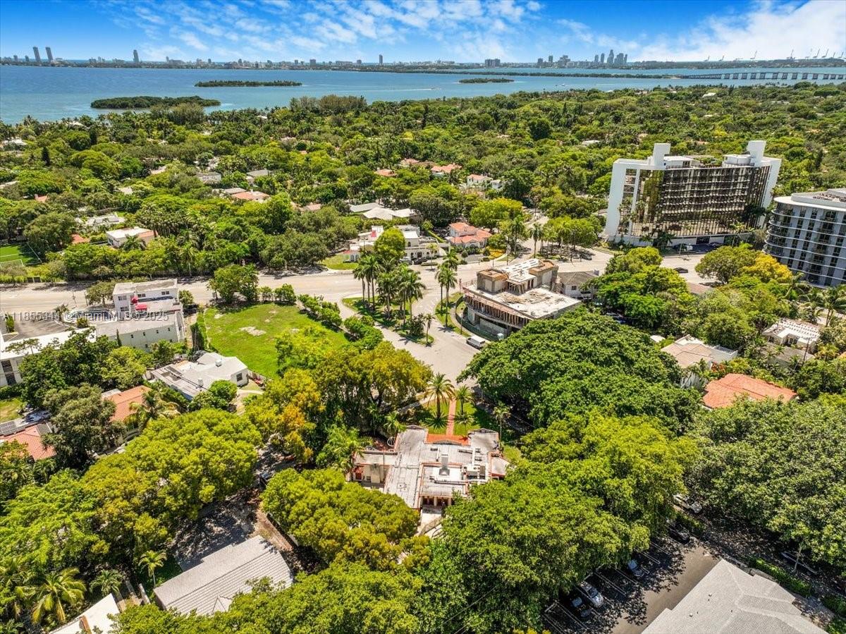 An aerial view shows a residential property surrounded by dense trees near a coastal bay — 5900 NE 5th Ave, Miami FL 33137, MIAMI, FL