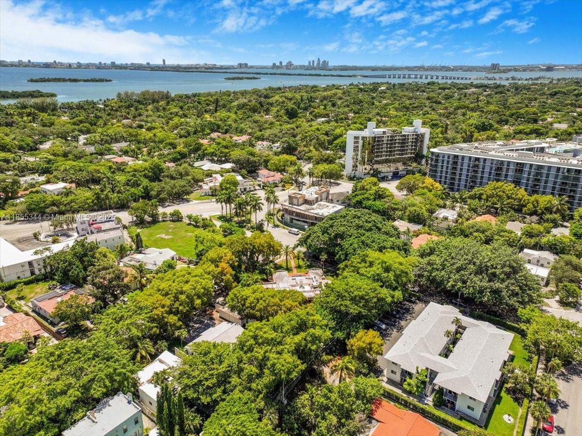 An aerial view shows a lush, tree-filled neighborhood near a bay with distant city skylines — 5900 NE 5th Ave, Miami FL 33137, MIAMI, FL