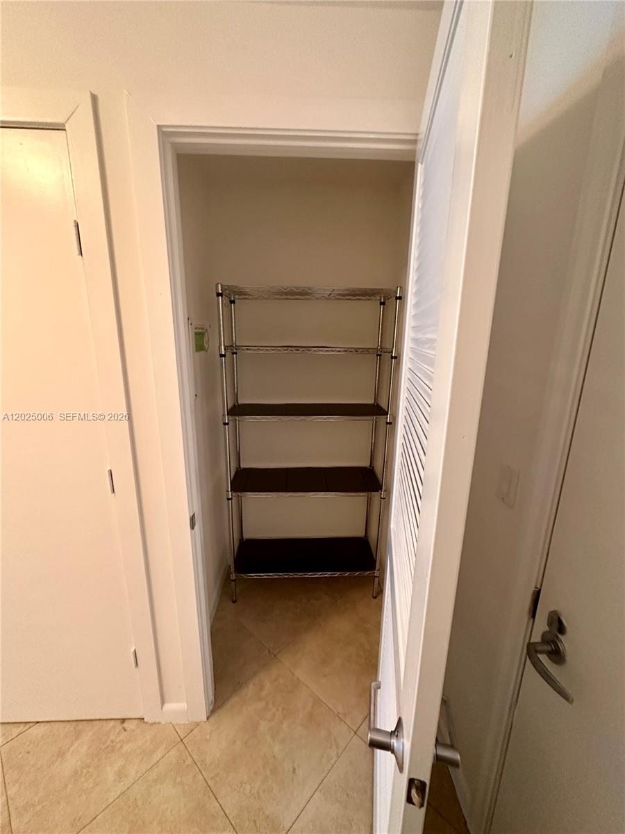 A small closet contains a four-tier metal wire shelving unit on a tiled floor — 1060 Brickell Ave # 2515, Miami FL 33131, MIAMI, FL