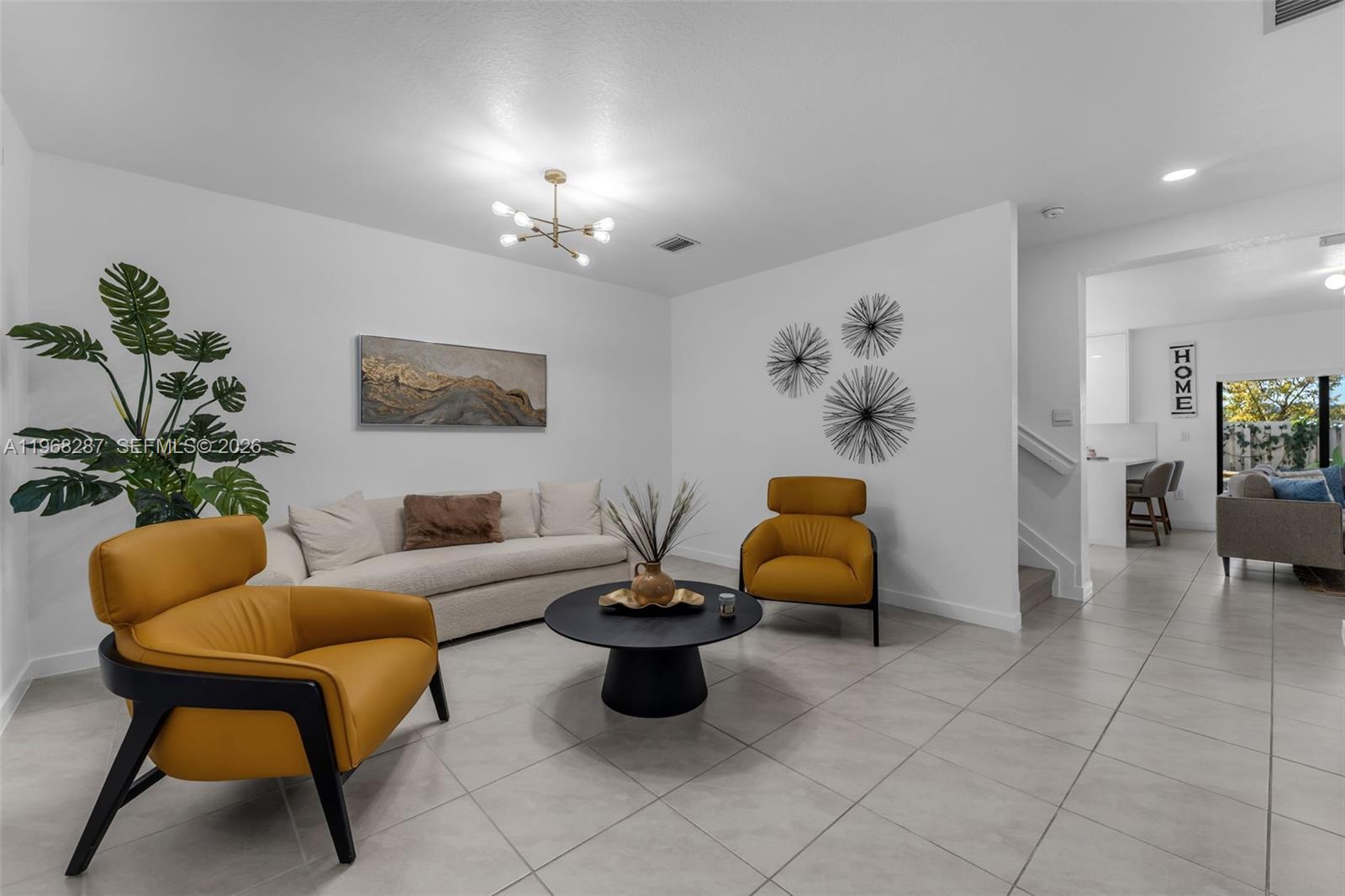 A living room features a beige sofa, two yellow armchairs, and a black coffee table — 514 NE 12th St, Florida City FL 33034, FLORIDA CITY, FL