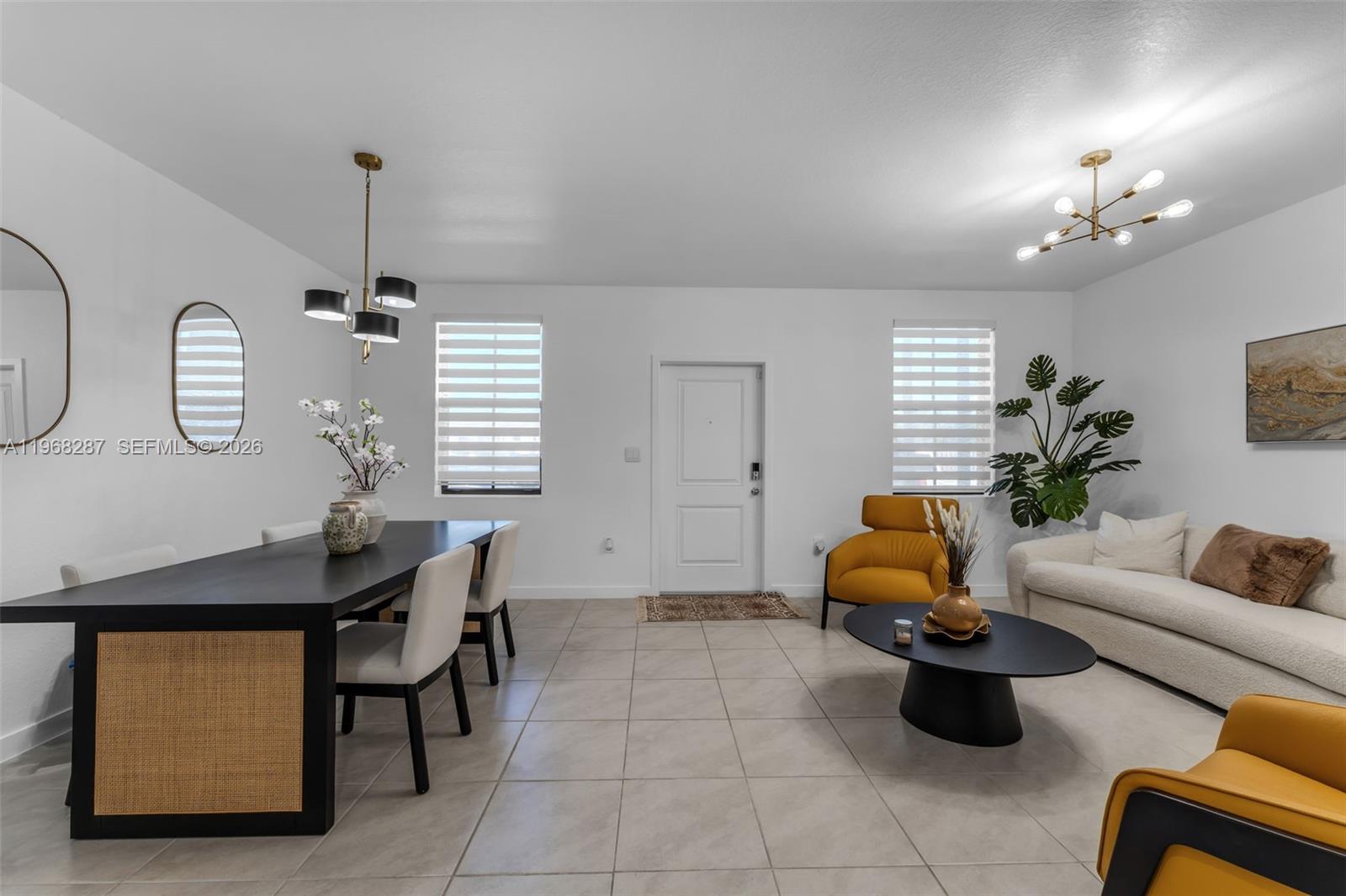 A bright open-concept living and dining area features white walls, tile floors, and modern furniture — 514 NE 12th St, Florida City FL 33034, FLORIDA CITY, FL