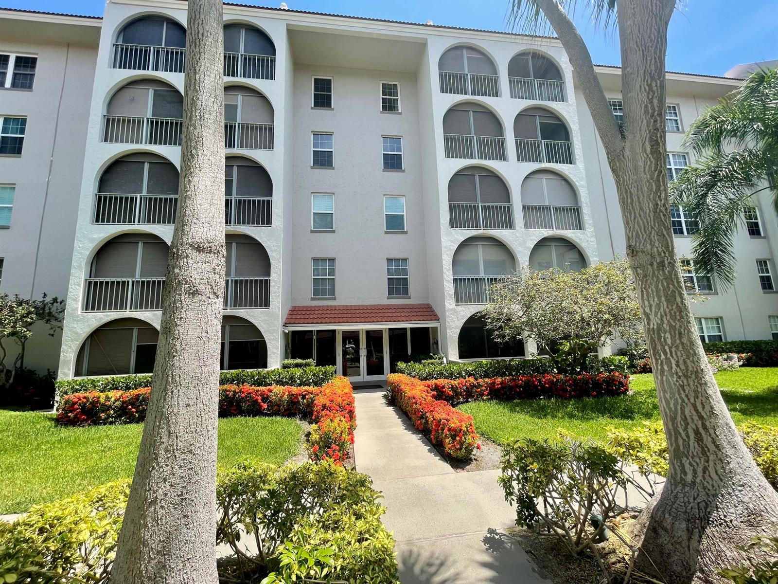 A multi-story apartment building features arched balconies and a central entrance with red tile roofing — 250 NE 20th Street # 3080, Boca Raton FL 33431, BOCA RATON, FL