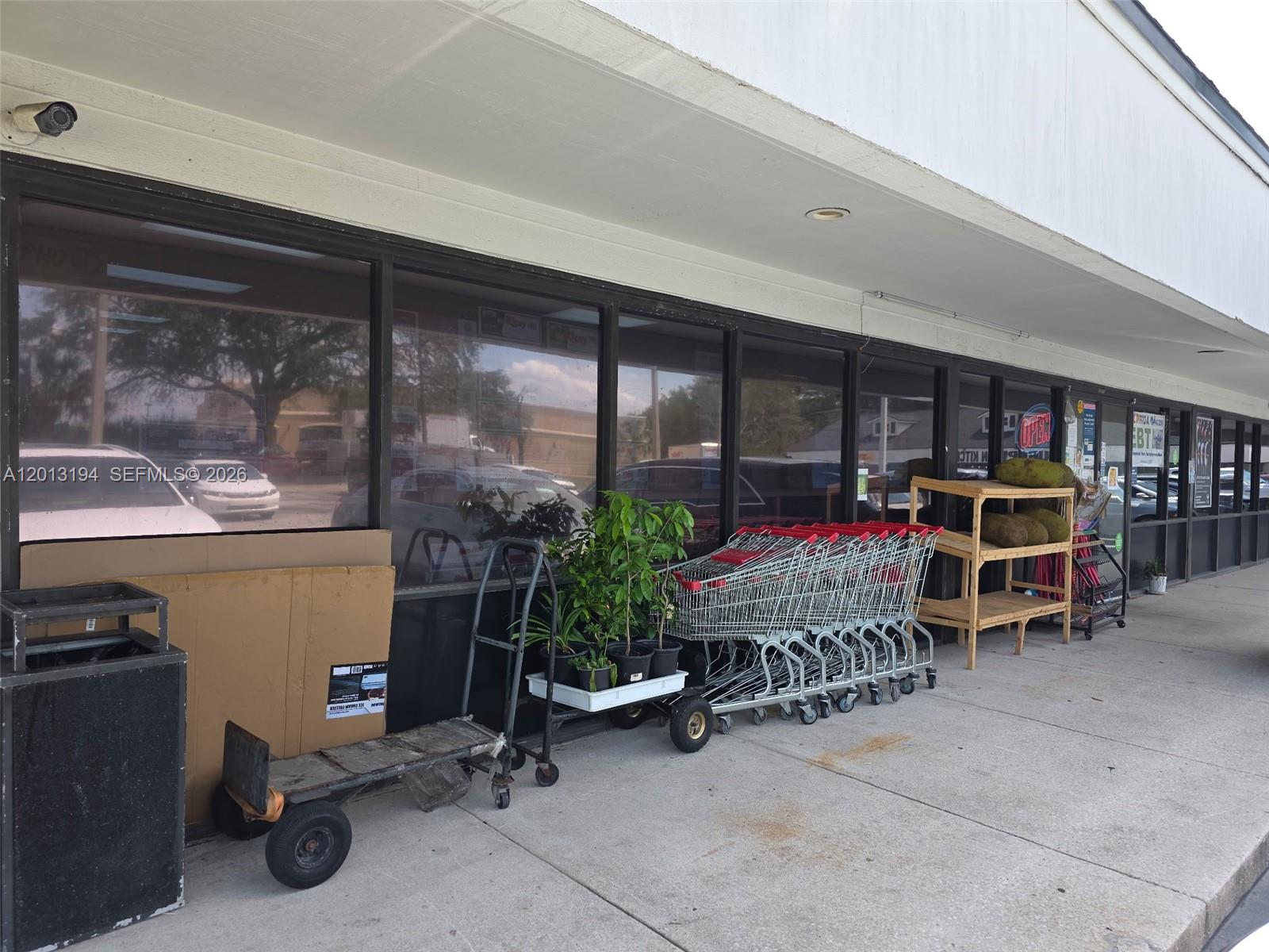 The exterior of a commercial building features a storefront with shopping carts and potted plants — 1704 S SOUTHSIDE BLVD, Jacksonville FL 32216, JACKSONVILLE, FL