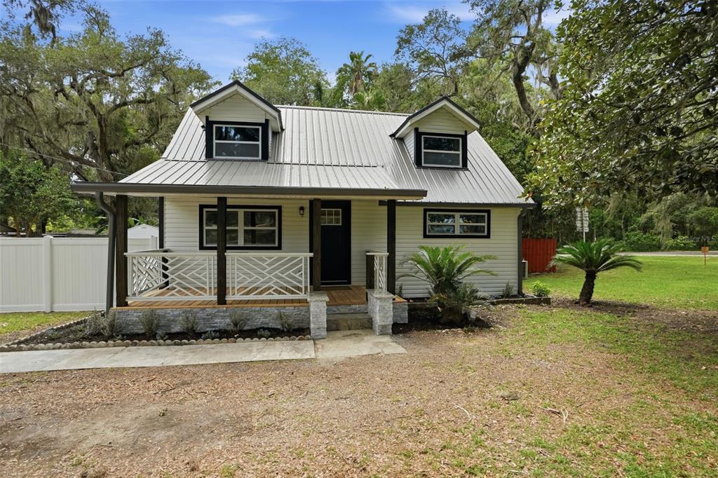 A white house with a metal roof, front porch, and two dormer windows — 14335 SNOW MEMORIAL HIGHWAY, BROOKSVILLE, FL