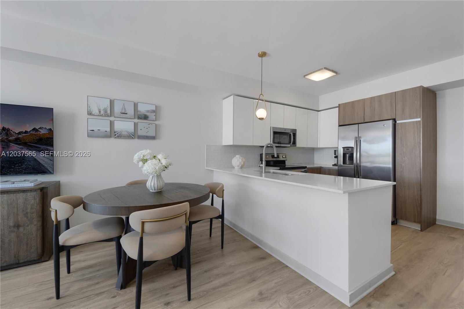 A modern kitchen with white cabinets and a dining area with a round table — 1501 SW 37th Ave # 1307, Miami FL 33145, MIAMI, FL