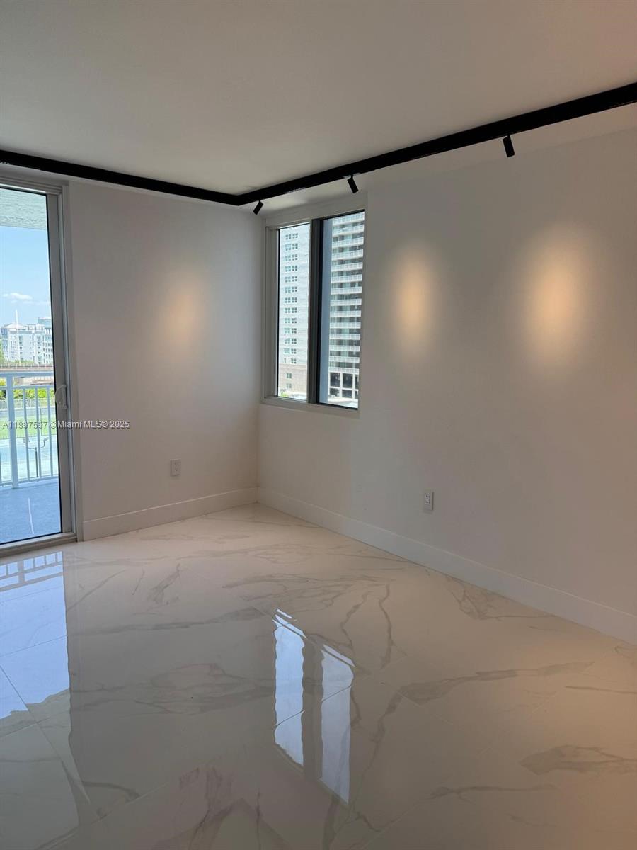 A bright room features white marble floors, recessed track lighting, and a sliding glass door — 800 N Miami Ave # 901, Miami FL 33136, MIAMI, FL