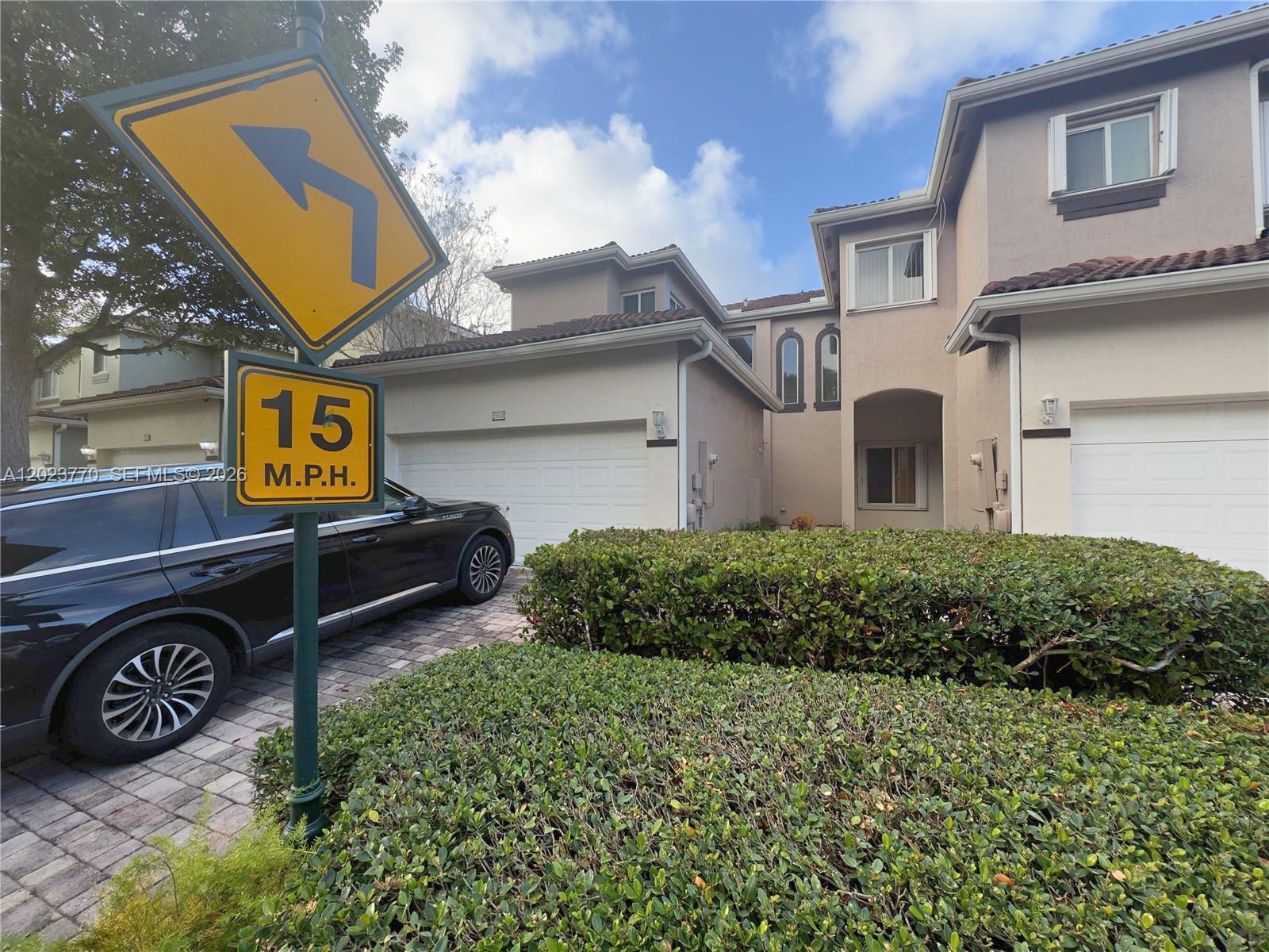A two-story residential building with a garage and a speed limit sign in the foreground — 2363 SE 19th St, Homestead FL 33035, HOMESTEAD, FL