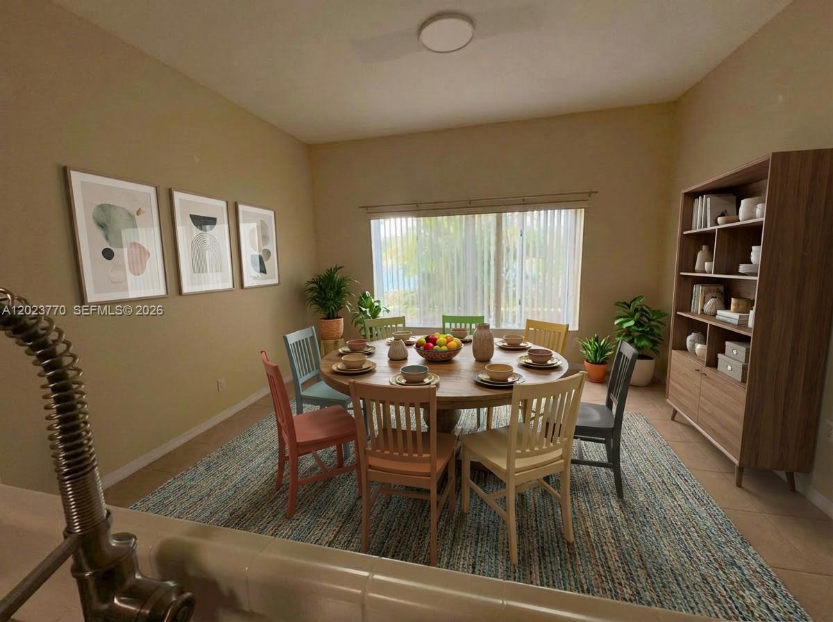 A dining room features a round wooden table, mismatched chairs, and a tall wooden bookshelf — 2363 SE 19th St, Homestead FL 33035, HOMESTEAD, FL