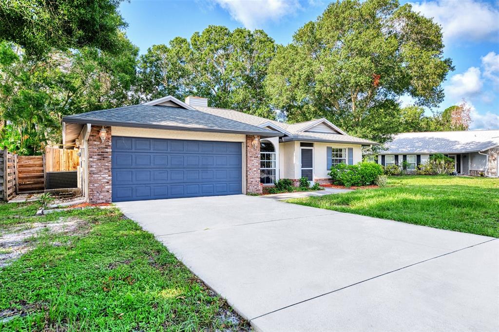 A single-story house with a blue garage door, brick accents, and a concrete driveway — 3026 GRAFTON STREET, SARASOTA, FL