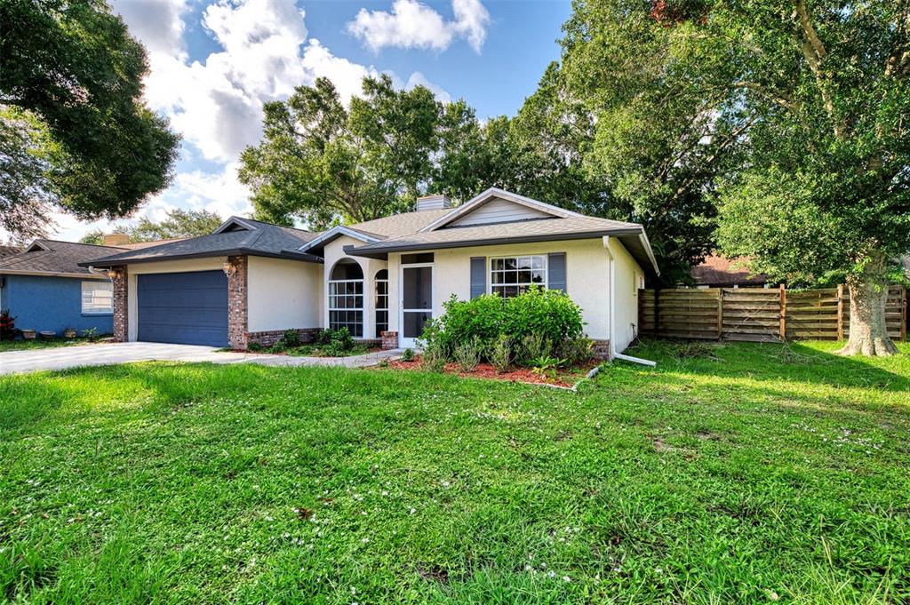 A single-story house with a blue garage, white stucco exterior, and a large front lawn — 3026 GRAFTON STREET, SARASOTA, FL