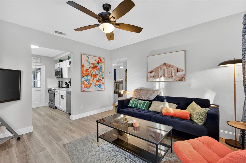 A living room features a dark blue sofa, glass coffee table, and an adjacent kitchen — 2301 14TH AVENUE N, ST PETERSBURG, FL