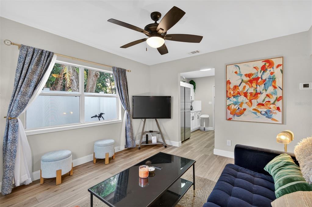 A living room features a ceiling fan, a television on a stand, and a blue sofa — 2301 14TH AVENUE N, ST PETERSBURG, FL