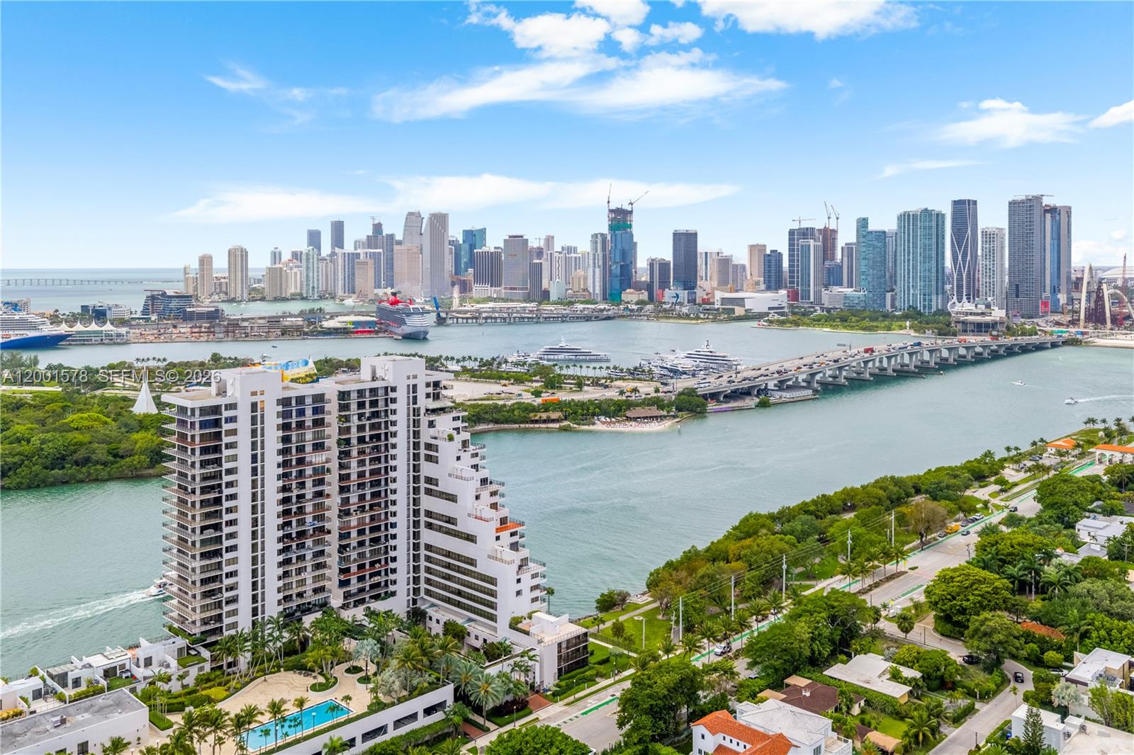 An aerial view shows a high-rise apartment building, a swimming pool, and a bridge — 1000 Venetian Way # 408, Miami FL 33139, MIAMI, FL