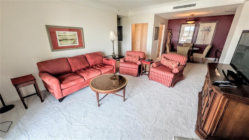 A living room features a red sofa, two matching armchairs, and a round coffee table — 750 N TAMIAMI TRAIL UNIT 1204, SARASOTA, FL