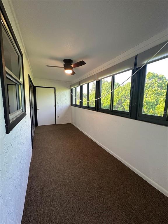 Exterior view of a two-story apartment building with beige stucco walls and outdoor staircases — 514 WINDRUSH BAY DRIVE UNIT 514, TARPON SPRINGS, FL