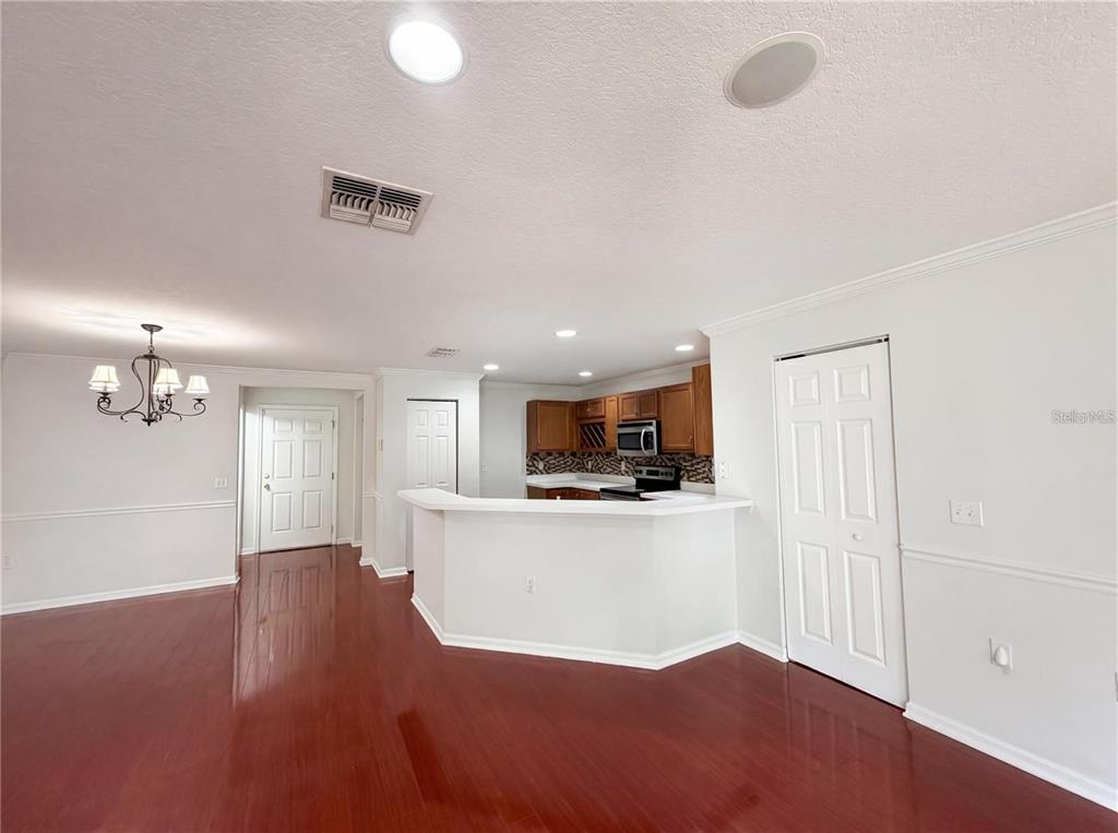 A kitchen with wood cabinets and a breakfast bar overlooks a dining area with flooring — 2972 ROYAL TUSCAN LANE, VALRICO, FL