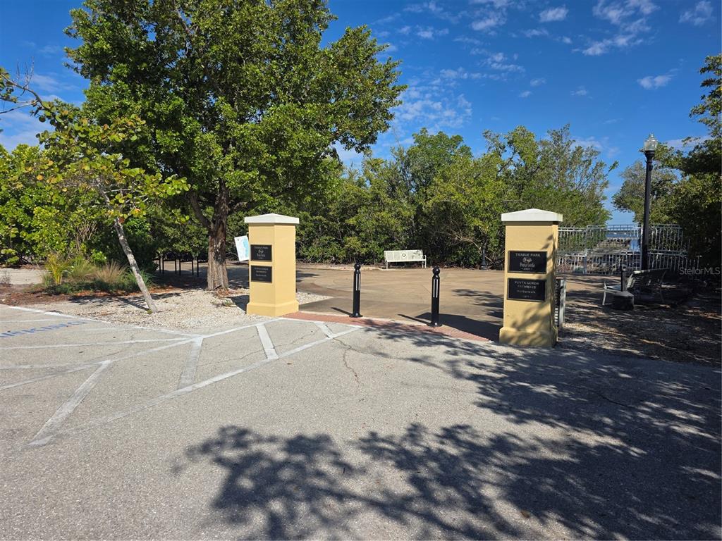 A paved entrance with two tan pillars leads to a park area with trees — 725 PATTY AVENUE, PUNTA GORDA, FL