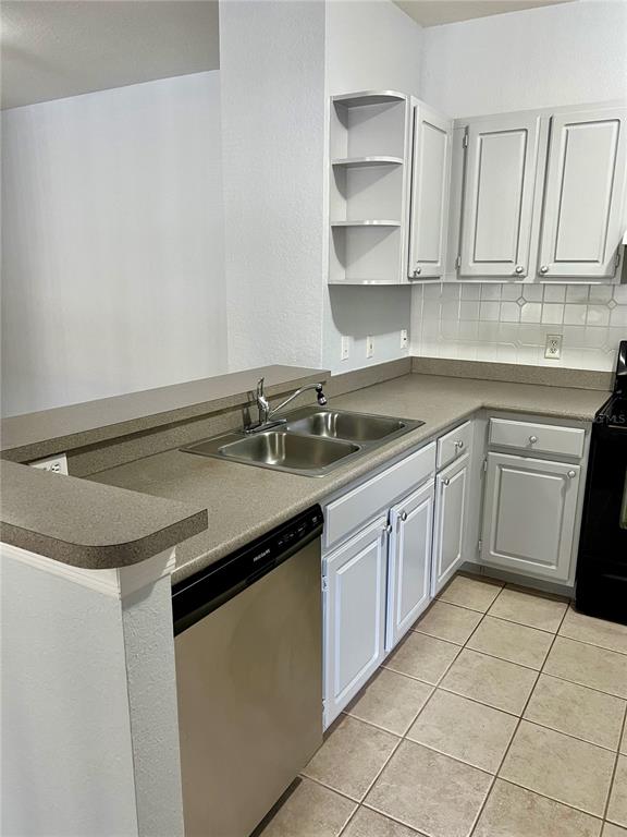 A kitchen features light gray cabinets, a stainless steel sink, and a dishwasher — 1100 LAKE SHADOW CIRCLE UNIT 2103, MAITLAND, FL