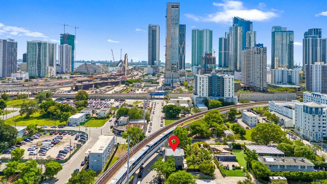 An aerial view shows a small building marked with a red pin near urban train tracks — 216 NW 11th St, Miami FL 33136, MIAMI, FL