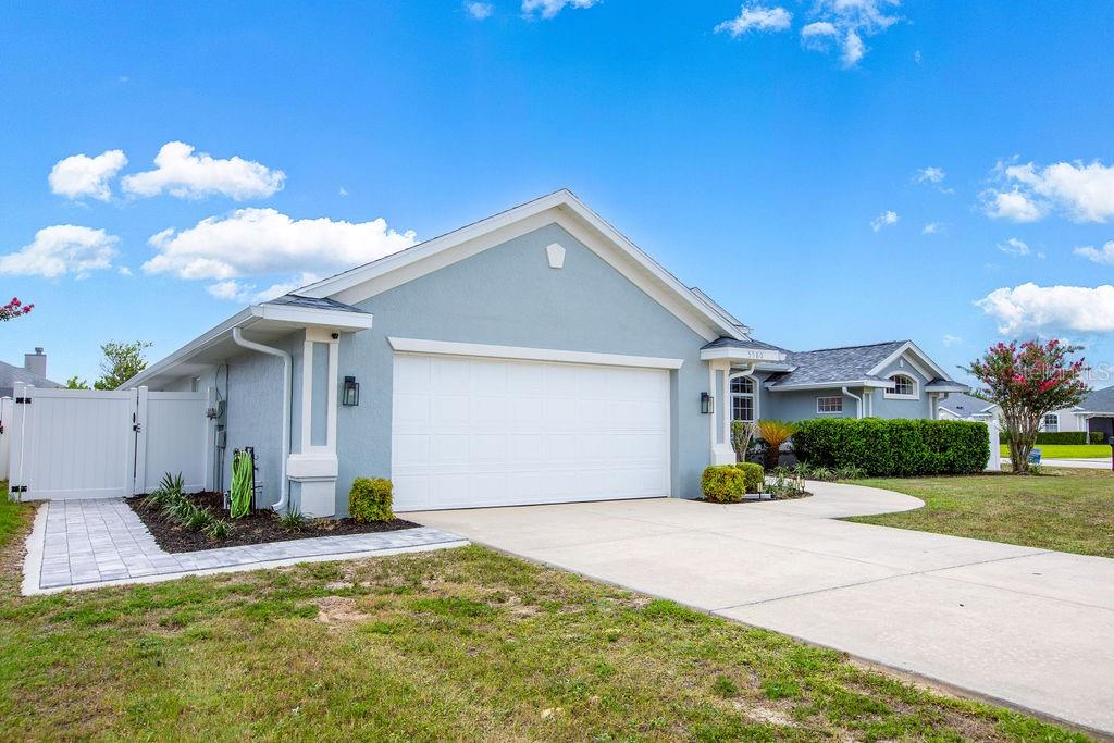 A light blue single-story house with a two-car garage and a white vinyl fence — 5580 SW 81ST PLACE, OCALA, FL