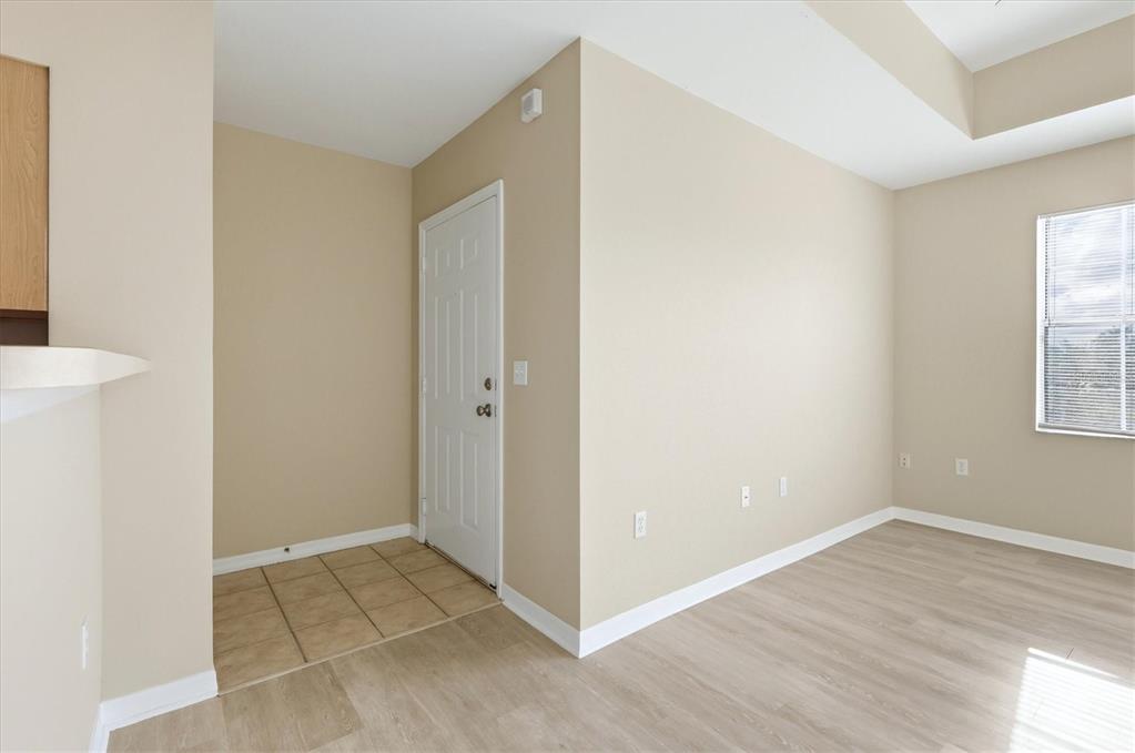 An entryway with tile flooring leads to a white door in a room with light-colored walls — 1015 VILLAGIO CIRCLE UNIT 202, SARASOTA, FL