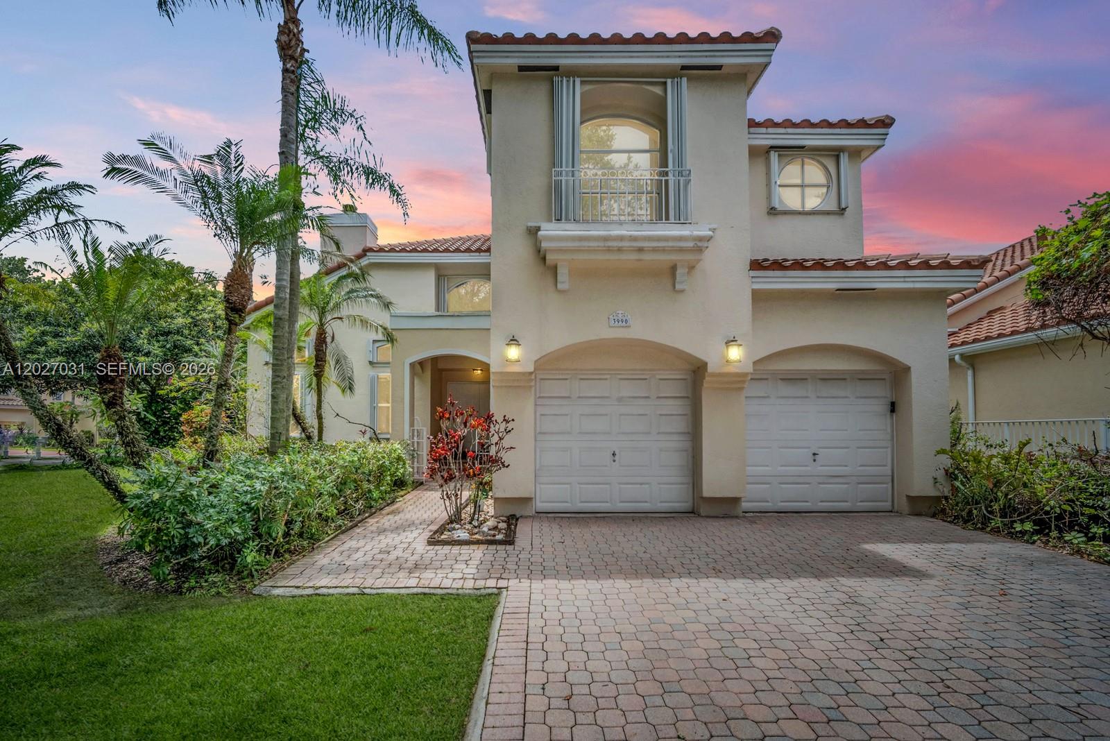 A two-story stucco house features a two-car garage, a paved driveway, and a balcony — 3990 Lansing Ave, Cooper City FL 33026, COOPER CITY, FL