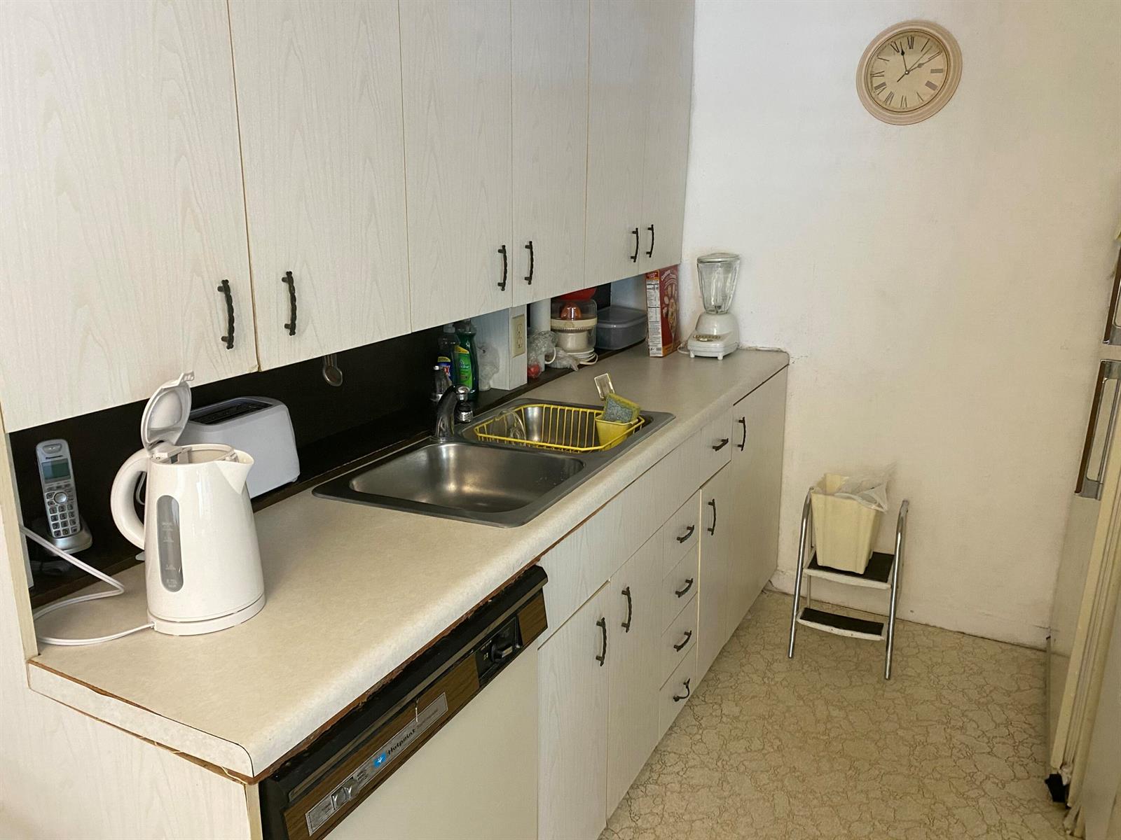 A kitchen features light wood cabinets, a stainless steel sink, and a white electric kettle — 2054 Ainslie D, Boca Raton FL 33434, BOCA RATON, FL