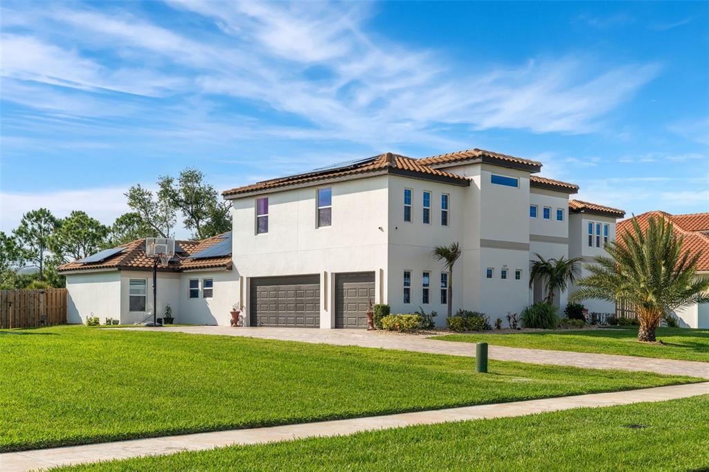 A two-story stucco house with a tile roof, solar panels, and a two-car garage — 3897 PROVINCE DRIVE, MELBOURNE, FL