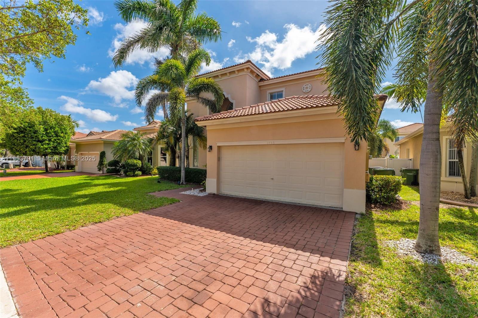 A two-story stucco house features a brick paver driveway and a two-car garage — 1755 NE 37th Ave # 0, Homestead FL 33033, HOMESTEAD, FL