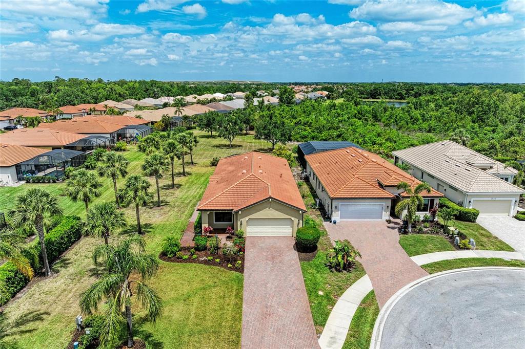 An aerial view shows two suburban houses with tile roofs and paved driveways — 10111 MALACHITE DRIVE, BRADENTON, FL