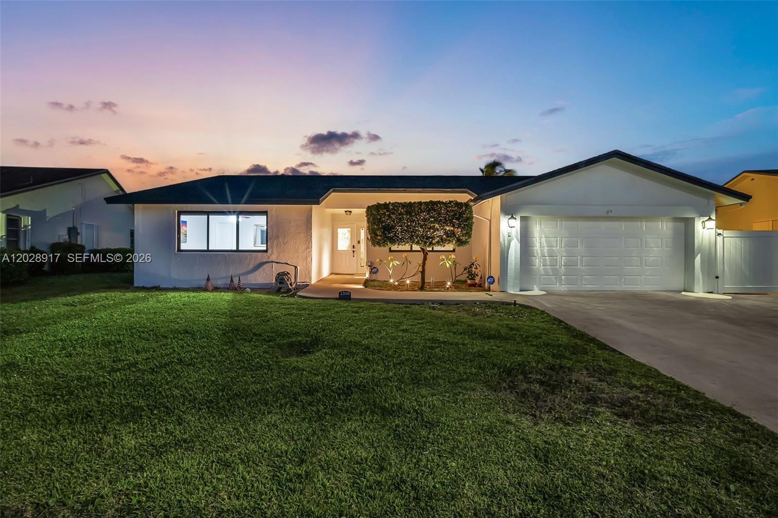 A single-story house with a white exterior, a two-car garage, and a manicured front lawn — 1310 SW 26th Ave, Deerfield Beach FL 33442, DEERFIELD BEACH, FL