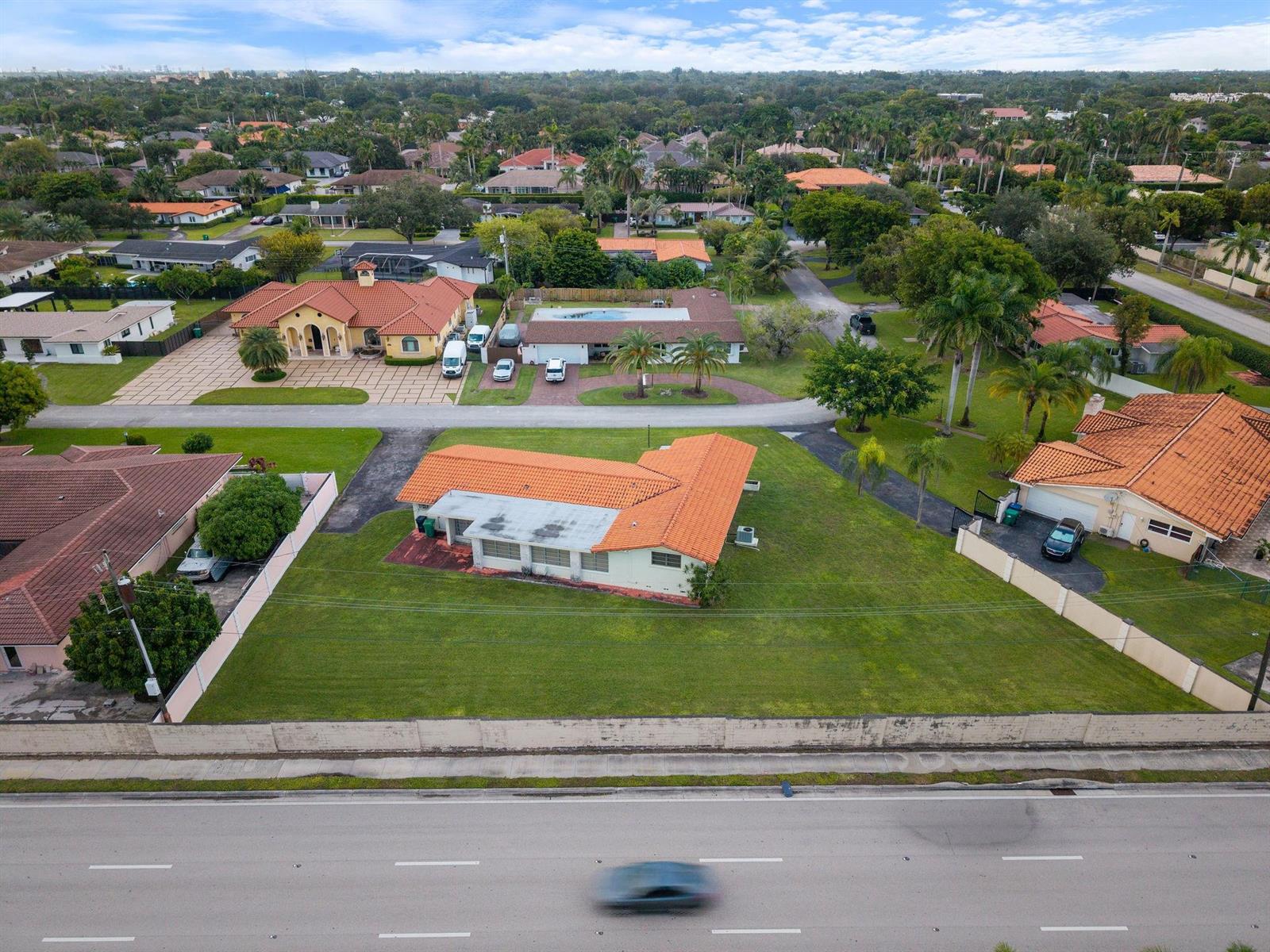 An aerial view shows a single-story house with a terracotta roof next to a road — 8230 SW 87th Terrace, Miami FL 33143, MIAMI, FL