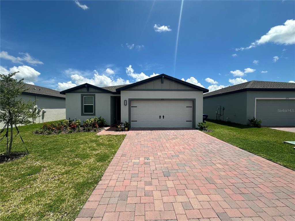 A single-story house with a paved driveway, a two-car garage, and a landscaped front yard — 3777 GIORGIO DRIVE, WINTER HAVEN, FL