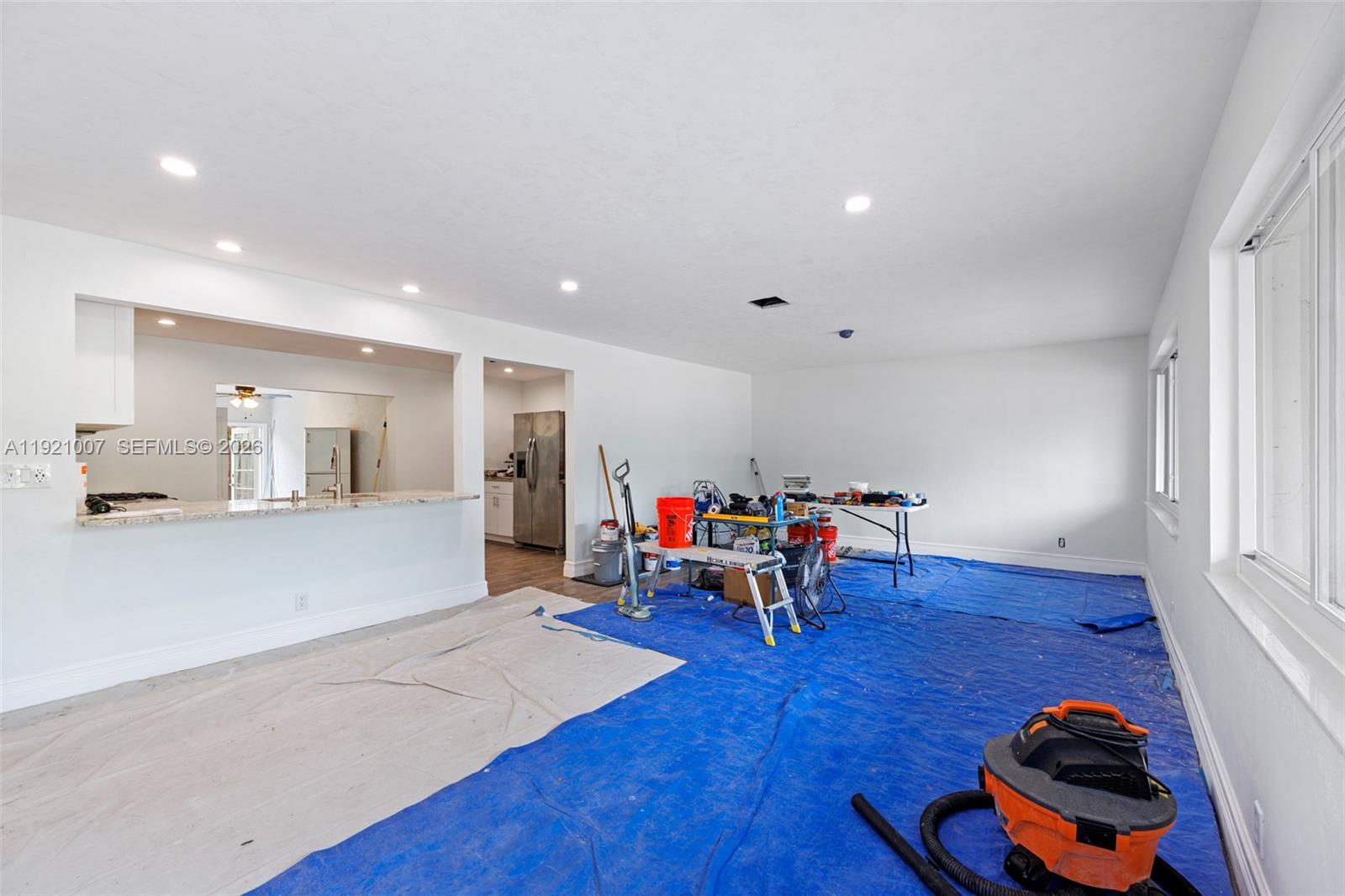 An unfinished room features white walls, recessed lighting, and blue protective floor coverings — 112 Milton St # 114, Lantana FL 33462, LANTANA, FL