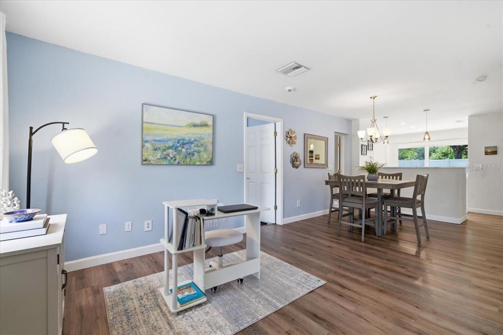A light blue room features a desk, a dining set, and wood-look flooring — 12291 MALLORY DRIVE, LARGO, FL