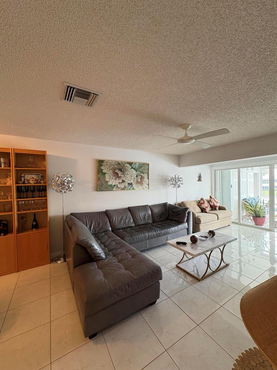 A living room features a grey sectional sofa, a marble coffee table, and tile flooring — 1421 NW 19th Terrace # 202, Delray Beach FL 33445, DELRAY BEACH, FL