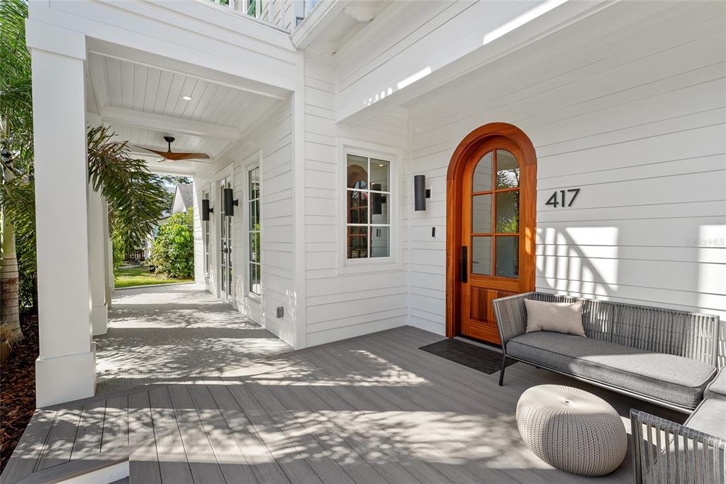 A white house exterior features a wooden arched front door and a gray deck — 417 N OSPREY AVENUE, SARASOTA, FL