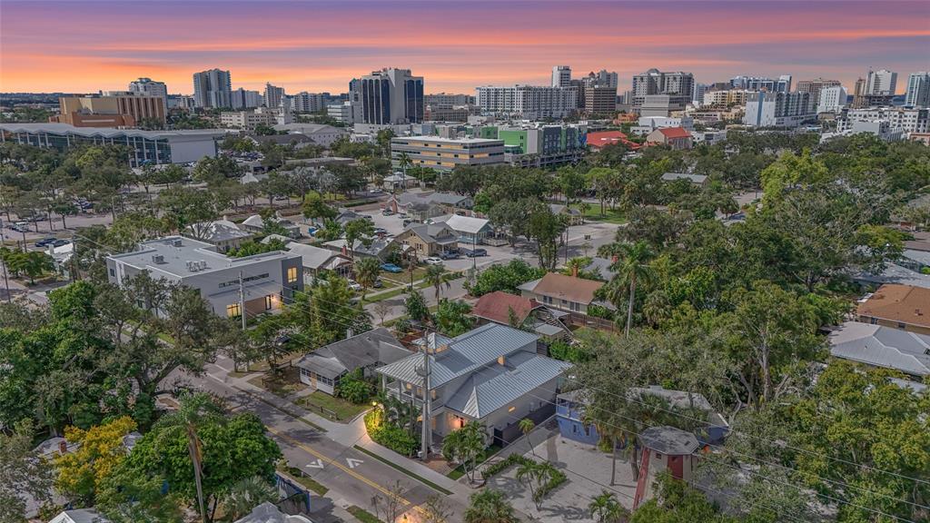 An aerial view of a residential neighborhood with a modern house and city skyline background — 417 N OSPREY AVENUE, SARASOTA, FL