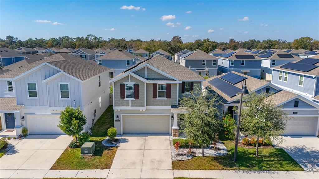 An exterior view of a two-story suburban house with a garage and solar panels — 1066 BERRY LANE, DAVENPORT, FL