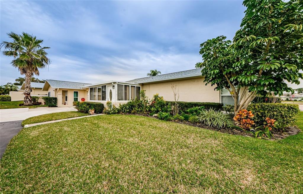 A single-story house with a lawn, palm tree, and a glass-enclosed porch — 2739 SHERBROOKE LANE UNIT B, PALM HARBOR, FL
