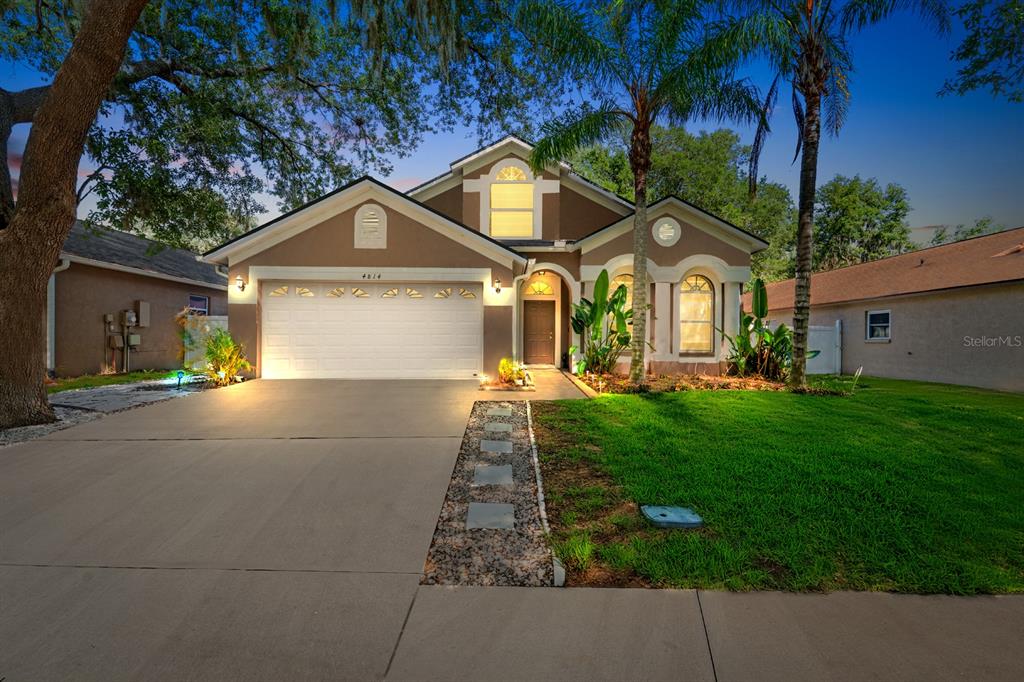 A single-story house with a two-car garage, a concrete driveway, and a front lawn — 4814 PORTOBELLO CIRCLE, VALRICO, FL