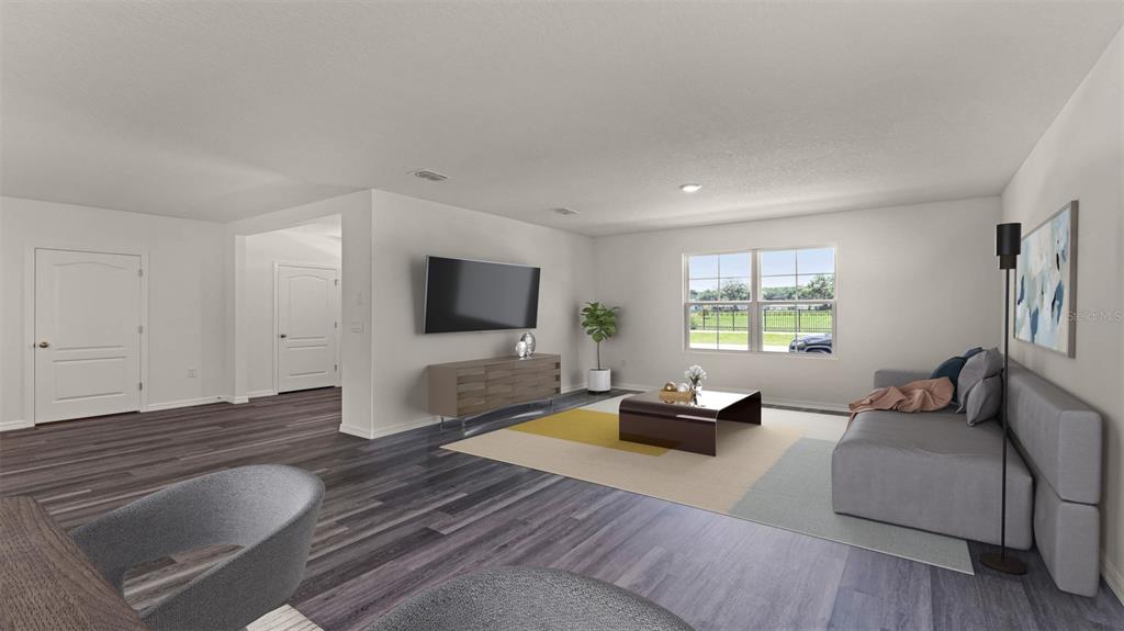 A living room features gray wood-look flooring, a large television, and a neutral-toned sofa — 5156 BLANKET FLOWER STREET, APOPKA, FL