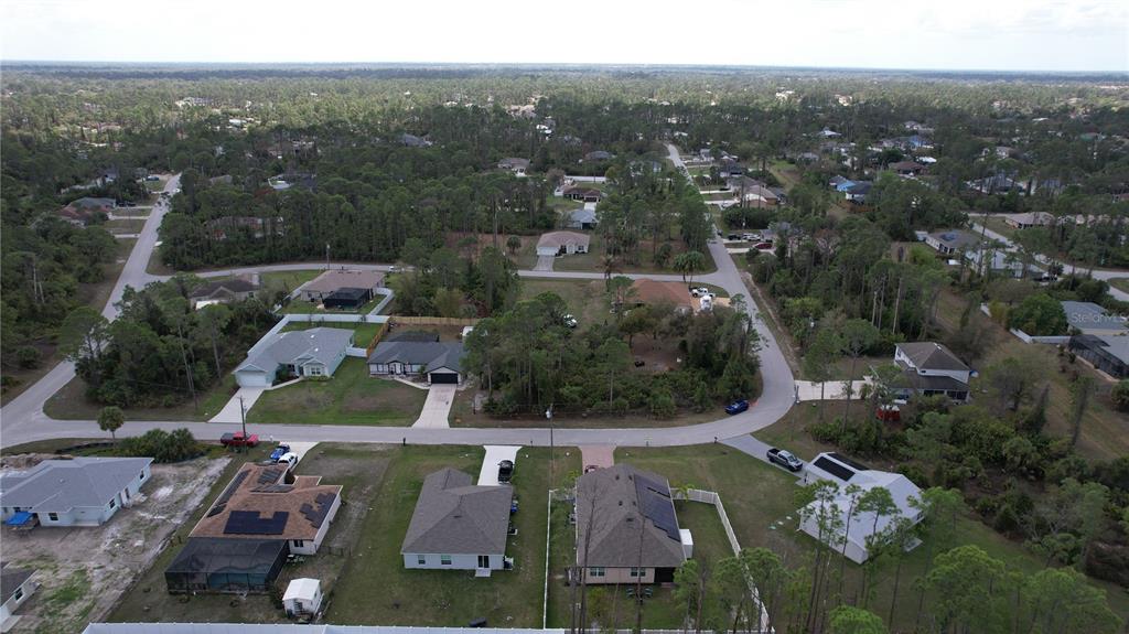 An aerial view shows a suburban neighborhood with single-family homes surrounded by wooded areas — GANTRY ROAD, NORTH PORT, FL