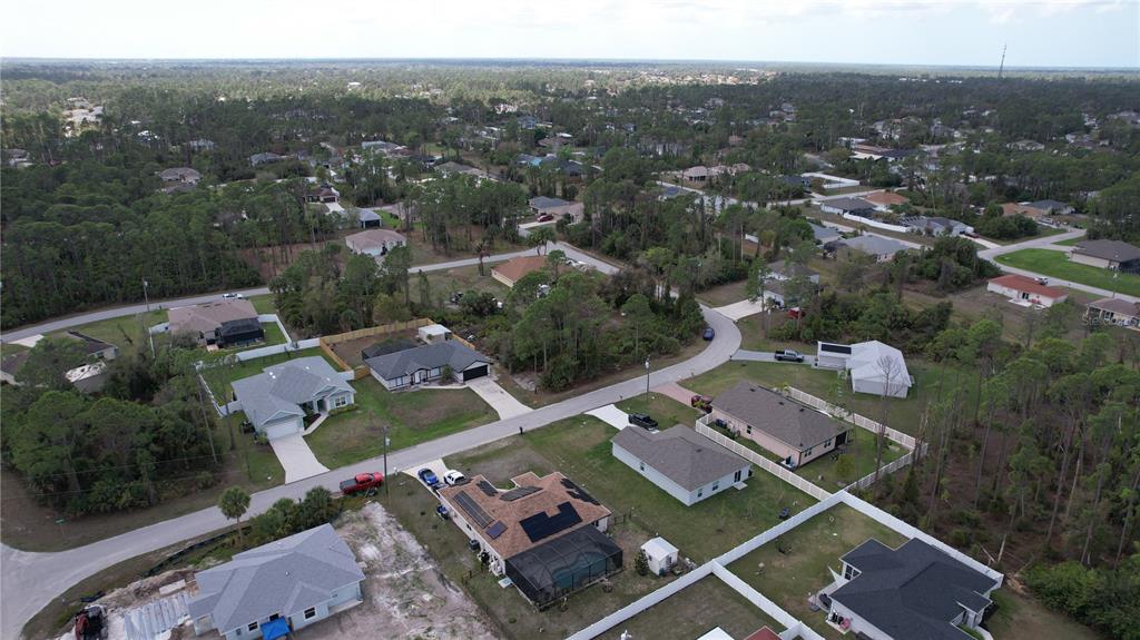 An aerial view shows several single-family homes surrounded by wooded areas and paved roads — GANTRY ROAD, NORTH PORT, FL