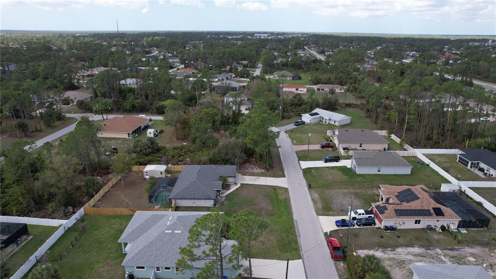 An aerial view shows several single-family homes surrounded by trees and a paved street — GANTRY ROAD, NORTH PORT, FL