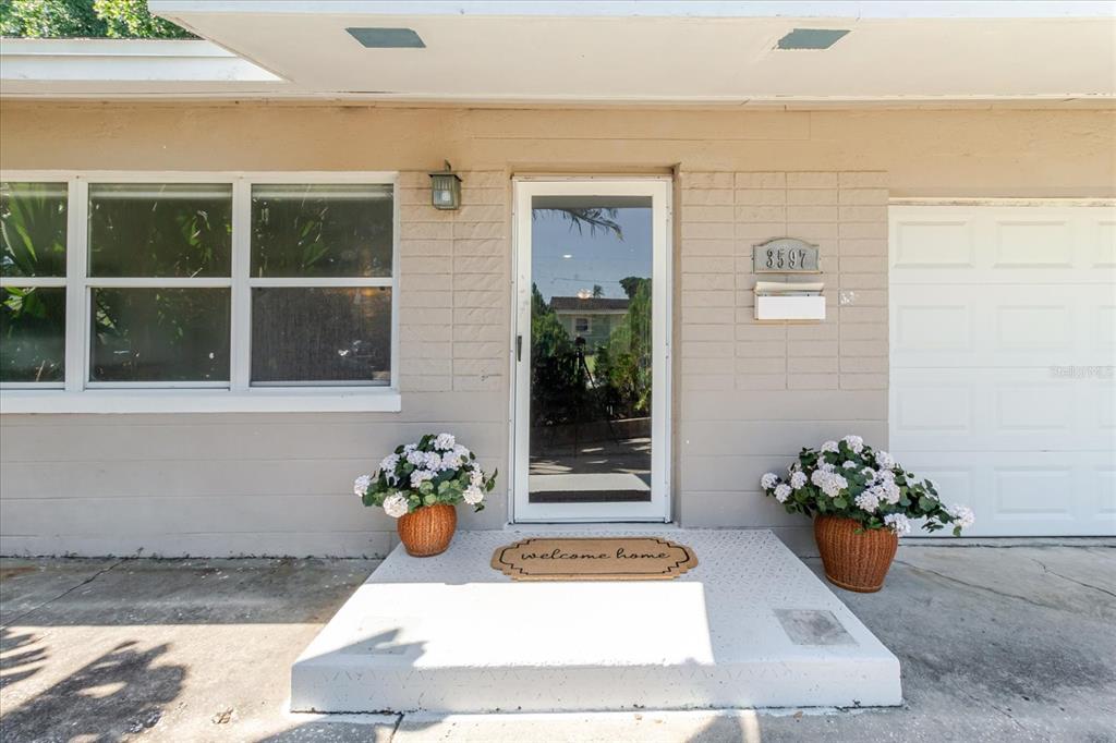 A living room with a sofa, TV, and open kitchen with a breakfast bar — 3597 27TH AVENUE S, ST PETERSBURG, FL