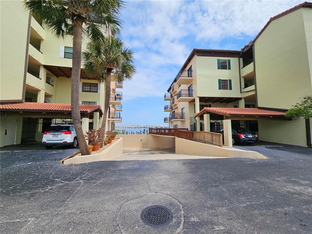 An exterior view shows two apartment buildings with covered parking and a view of water — 632 MARINA POINT DRIVE UNIT 6320, DAYTONA BEACH, FL