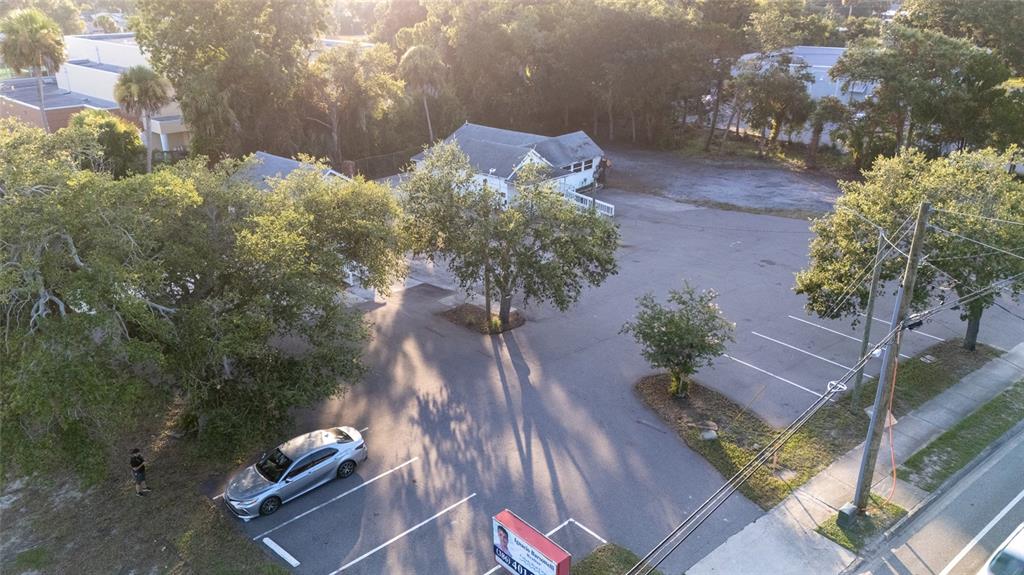 An aerial view shows a parking lot with two small buildings and several trees — 1042 N DIXIE FREEWAY, NEW SMYRNA BEACH, FL